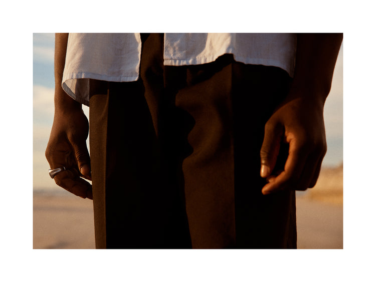 Man wearing white shirt and brown slacks.