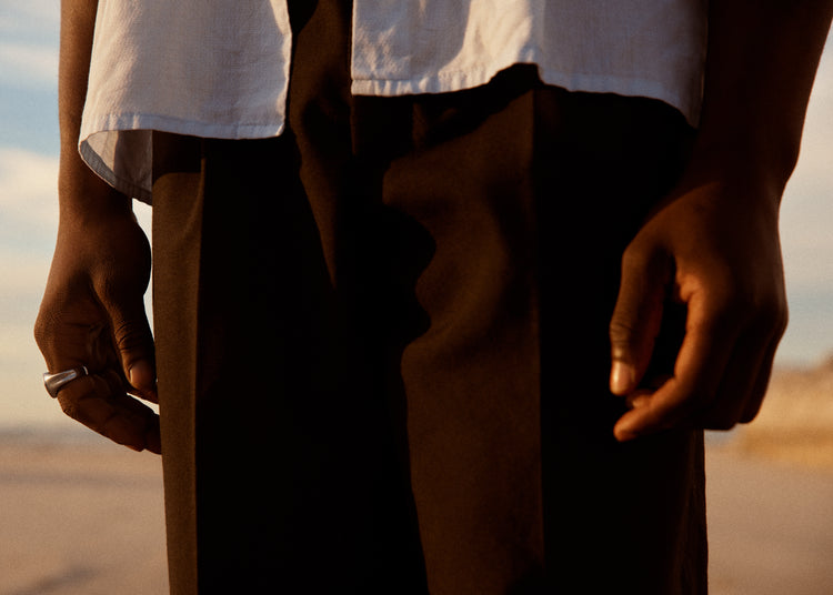 Man wearing white shirt and brown slacks.