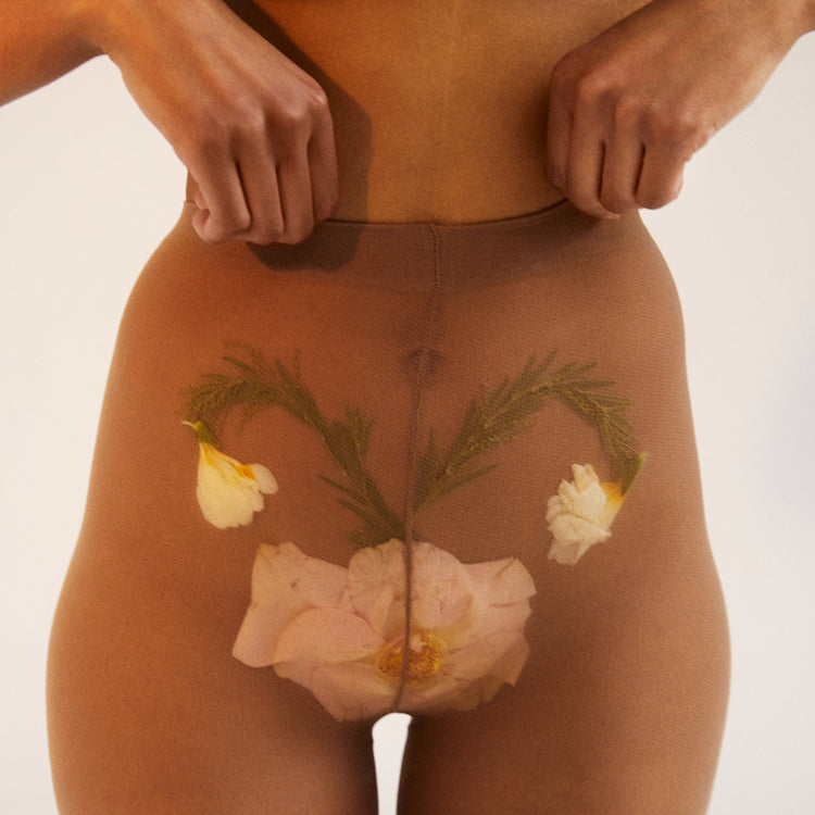 A woman in transparent stockings with a flower symbolizing her uterus.