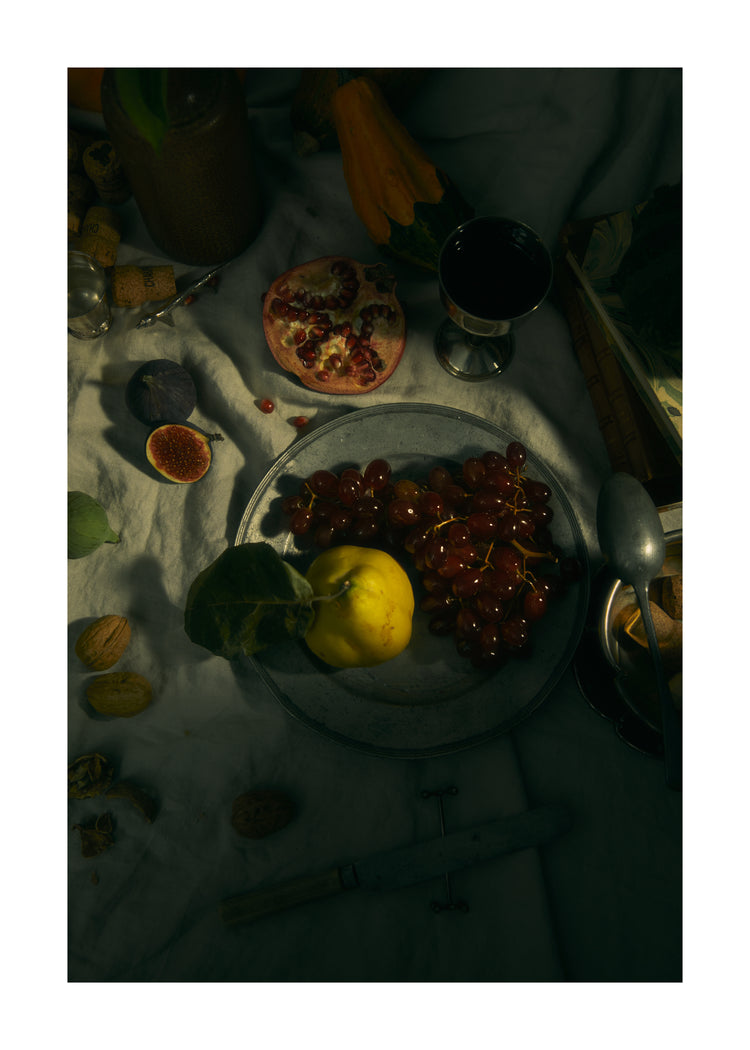Still life photograph of a sheet with different fruits and objects on it.