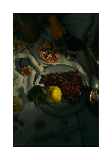 Still life photograph of a sheet with different fruits and objects on it.