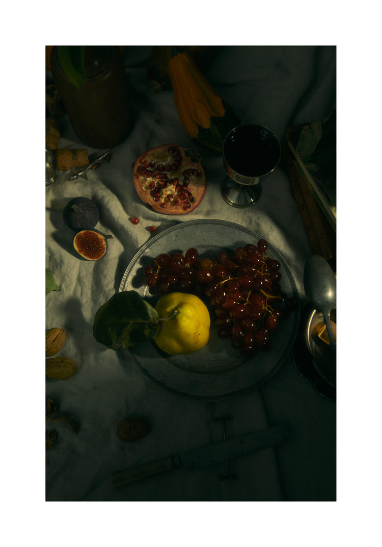 Still life photograph of a sheet with different fruits and objects on it.