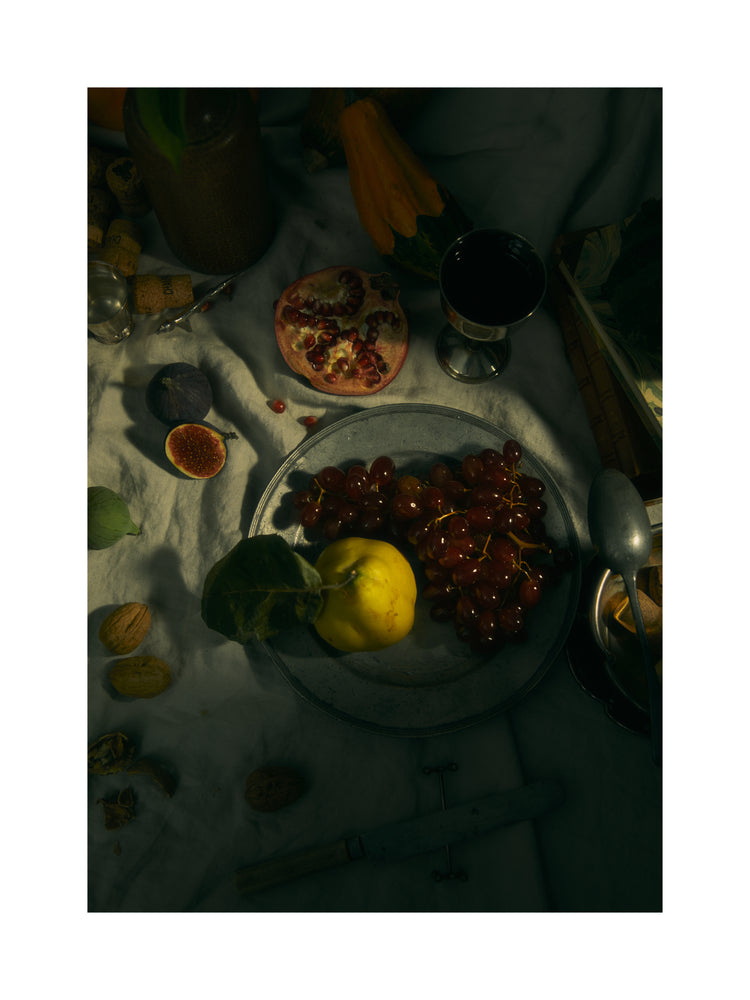 Still life photograph of a sheet with different fruits and objects on it.