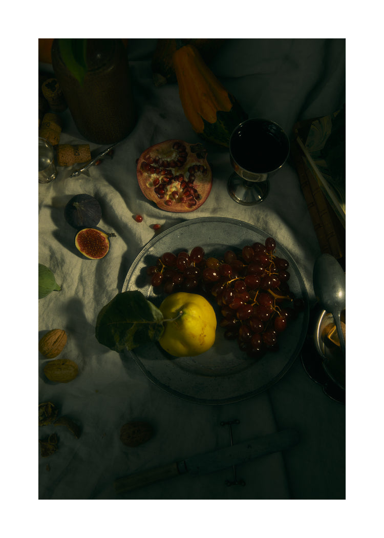 Still life photograph of a sheet with different fruits and objects on it.