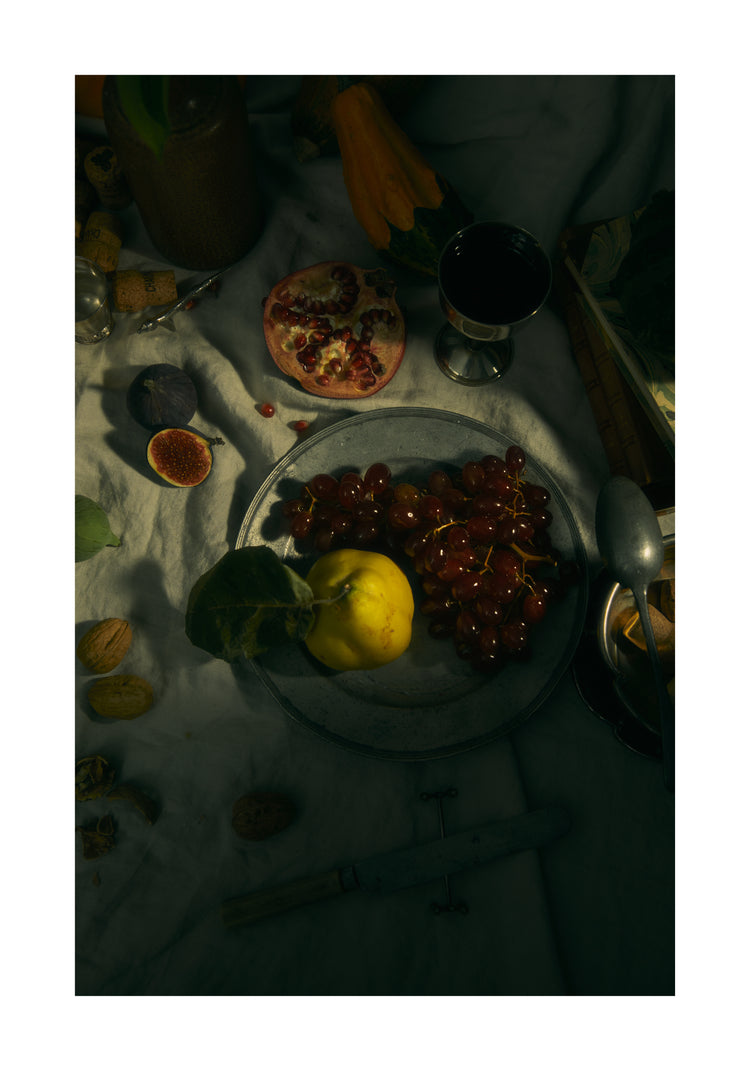Still life photograph of a sheet with different fruits and objects on it.