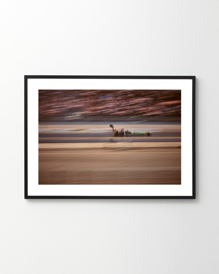 The Limitless Poster features a blurred racehorse and jockey, capturing the thrill of high-speed racing. The motion blur emphasizes their dynamic pace against a backdrop of indistinct spectators. Displayed on a pristine white wall, this framed artwork embodies the essence of seizing lifes momentums.