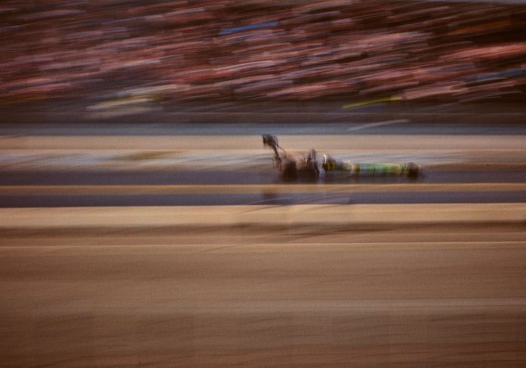 Blurry image of a cast going fast on a race car track.