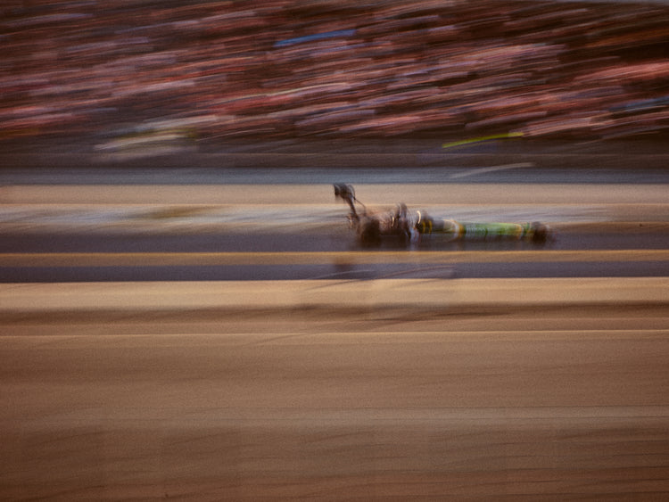 Blurry image of a cast going fast on a race car track.