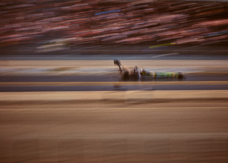 Blurry image of a cast going fast on a race car track.