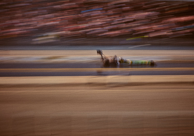 Blurry image of a cast going fast on a race car track.