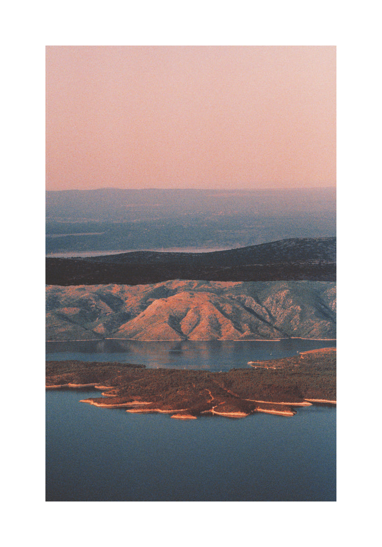 Landscape scenery with mountains and forests and lakes under crimson sky.