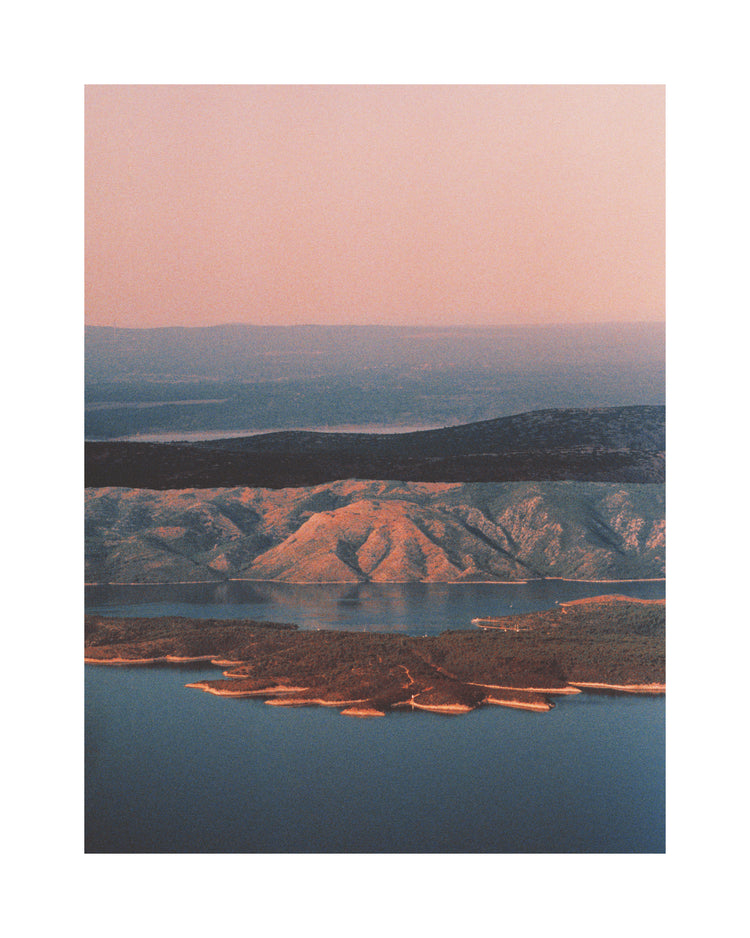 Landscape scenery with mountains and forests and lakes under crimson sky.