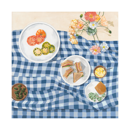 The Poppies and Picnics poster captures summertime romance with a blue checkered tablecloth displaying sliced tomatoes, sandwiches, a creamy dessert, olives, and flowers—perfect for your kitchen wall.