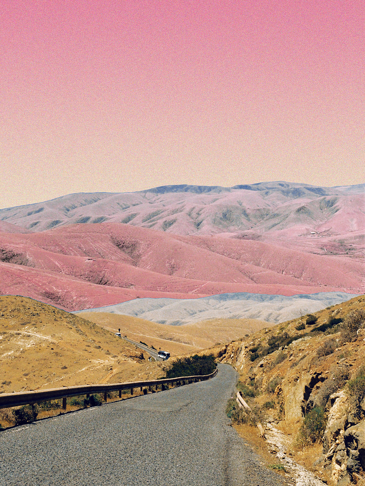 Technicolor scenic landscape with pink and purple mountains under a pink sky.