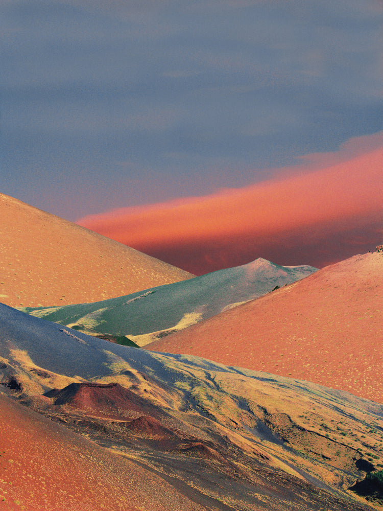 Colorful mountain scenery sparkling under a blue sky with crimson clouds.