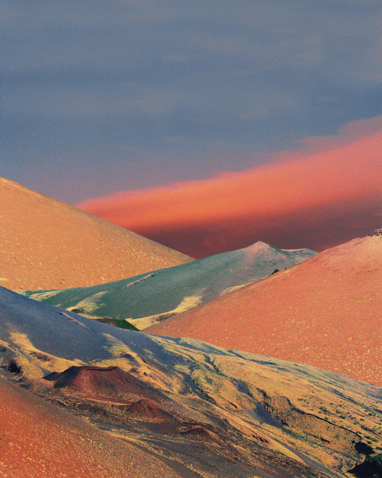 Colorful mountain scenery sparkling under a blue sky with crimson clouds.