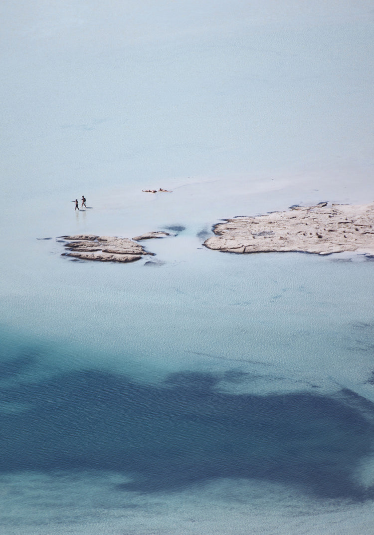 Shallow white and blue waters mirroring the sky up above.