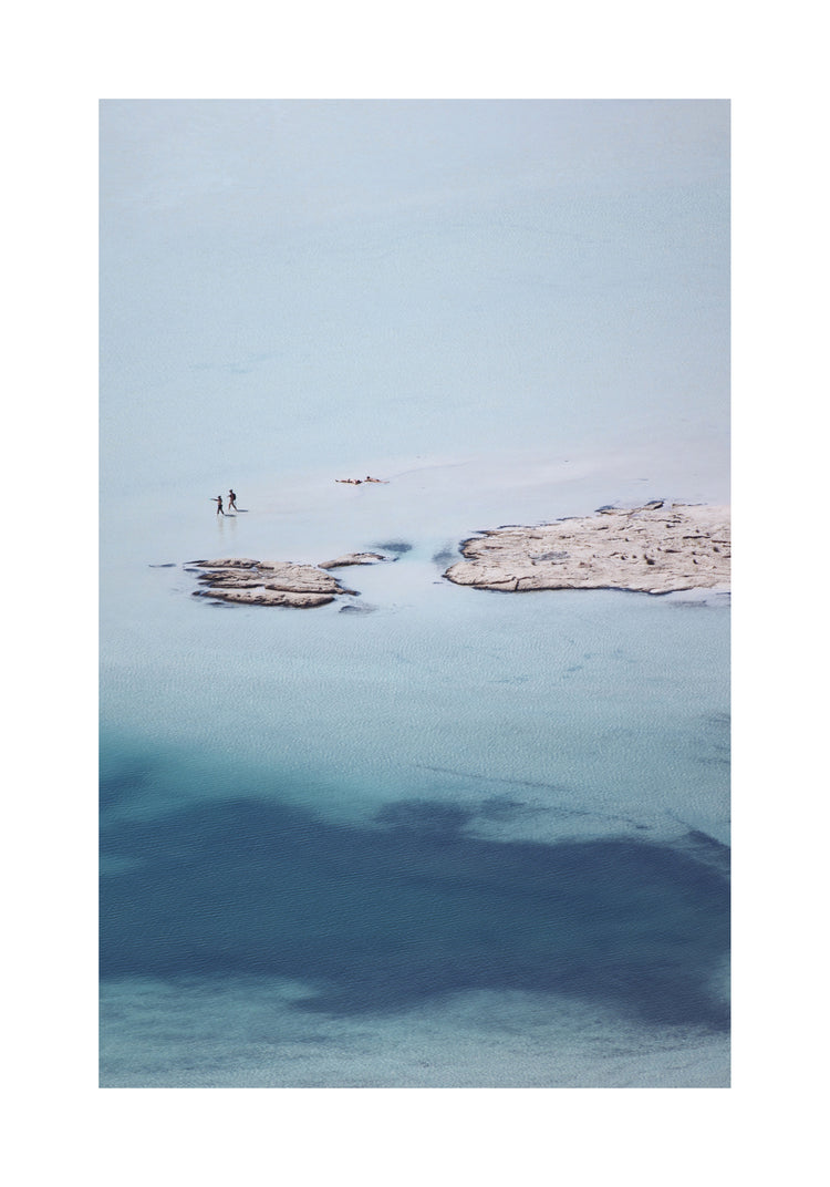 Shallow white and blue waters mirroring the sky up above.