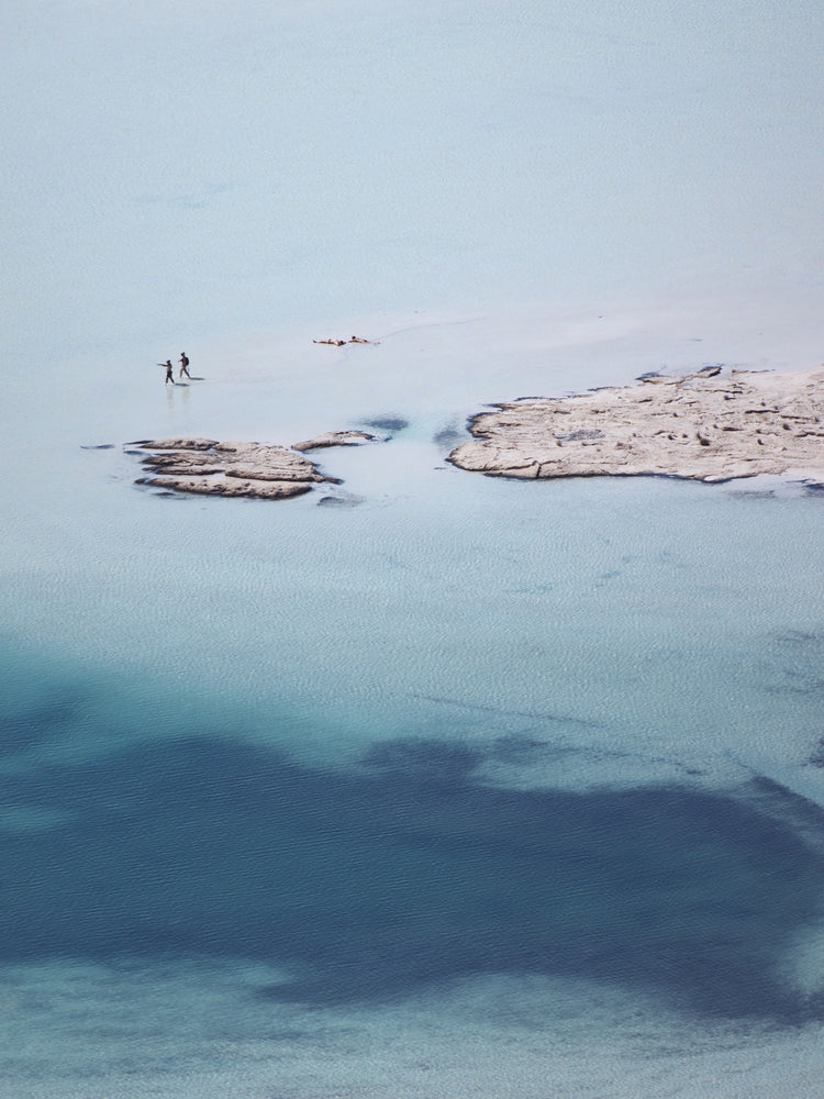 Shallow white and blue waters mirroring the sky up above.