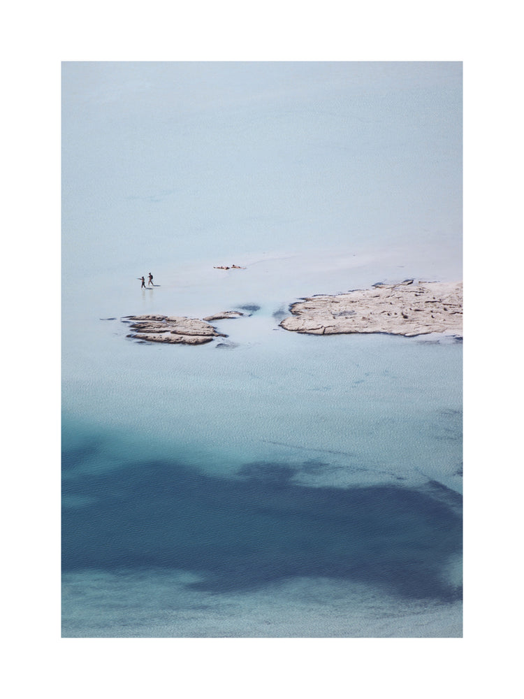Shallow white and blue waters mirroring the sky up above.
