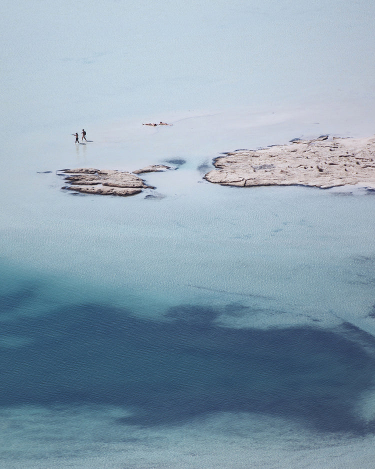Shallow white and blue waters mirroring the sky up above.