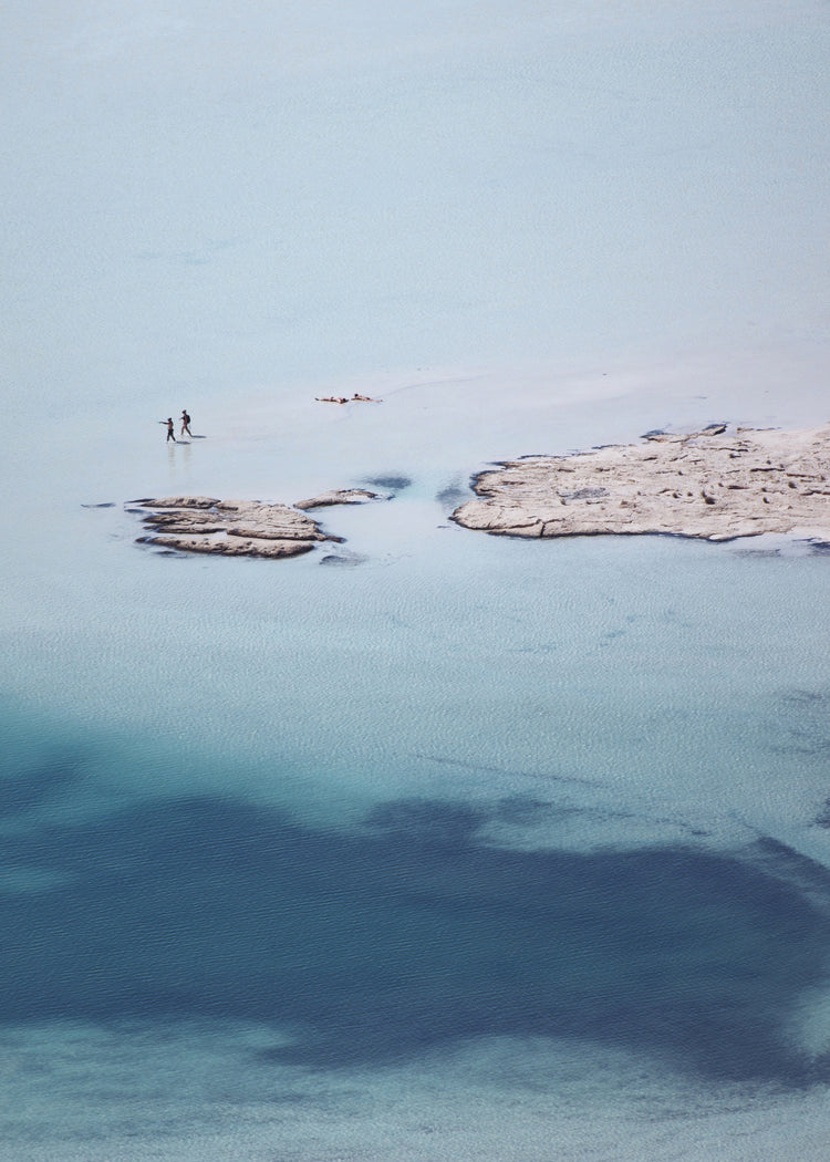 Shallow white and blue waters mirroring the sky up above.