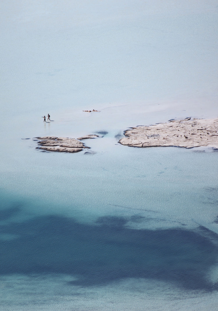 Shallow white and blue waters mirroring the sky up above.