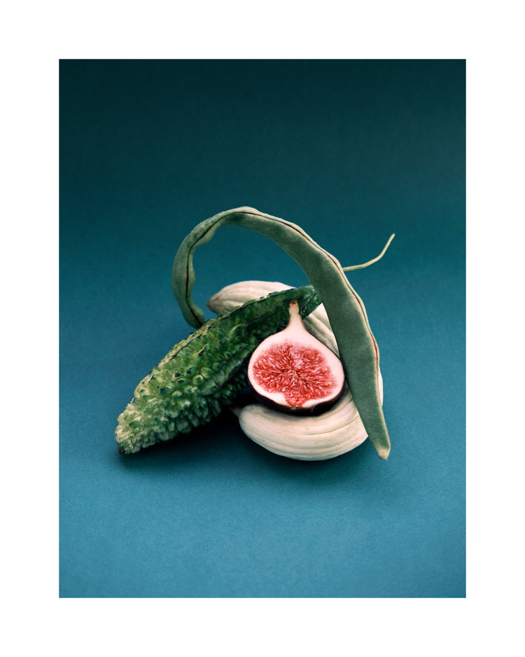 Different fruits and vegetables stacked together on a turquoise canvas.