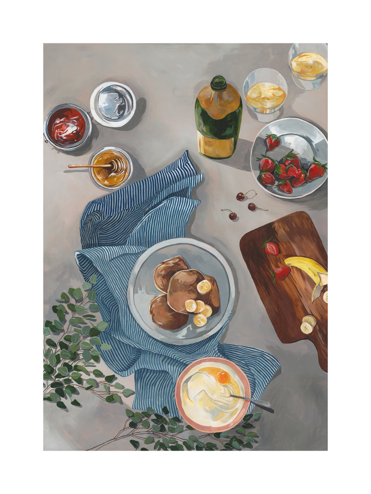The Breakfast of Champions Poster features fluffy pancakes with banana slices, set on a striped cloth, surrounded by honey and jam jars, sparkling champagne, strawberries, yogurt bowls, oranges, and a cutting board holding fresh bananas and strawberries.