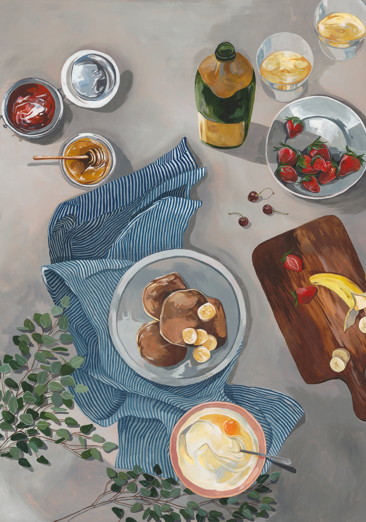 The Breakfast of Champions Poster features a table adorned with fluffy pancakes topped with banana slices, set on a blue striped cloth, accompanied by honey, yogurt, two drinks ideal for pairing with champagne, strawberries in a bowl, and a cutting board with sliced bananas and strawberries.