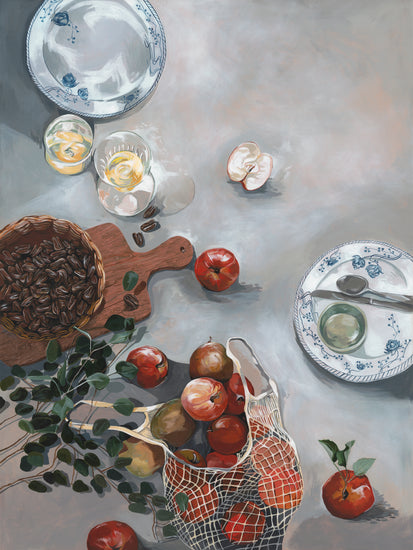 The How Do You Like These Apples Poster depicts a still life of a kitchen table with red apples, a mesh bag, pecans on a wooden board, plates with utensils, glasses of light beverage, and eucalyptus branches scattered across the textured surface for warm decor.