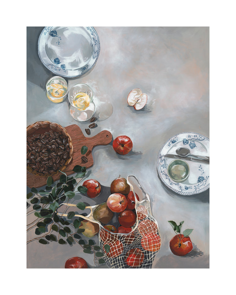 The How Do You Like These Apples Poster features a kitchen table set with two plates, one with cutlery, glasses of lemonade, a wooden board with pecans, and a mesh bag holding red apples and oranges, all framed by scattered leaves and a peeled garlic clove for an inviting scene.