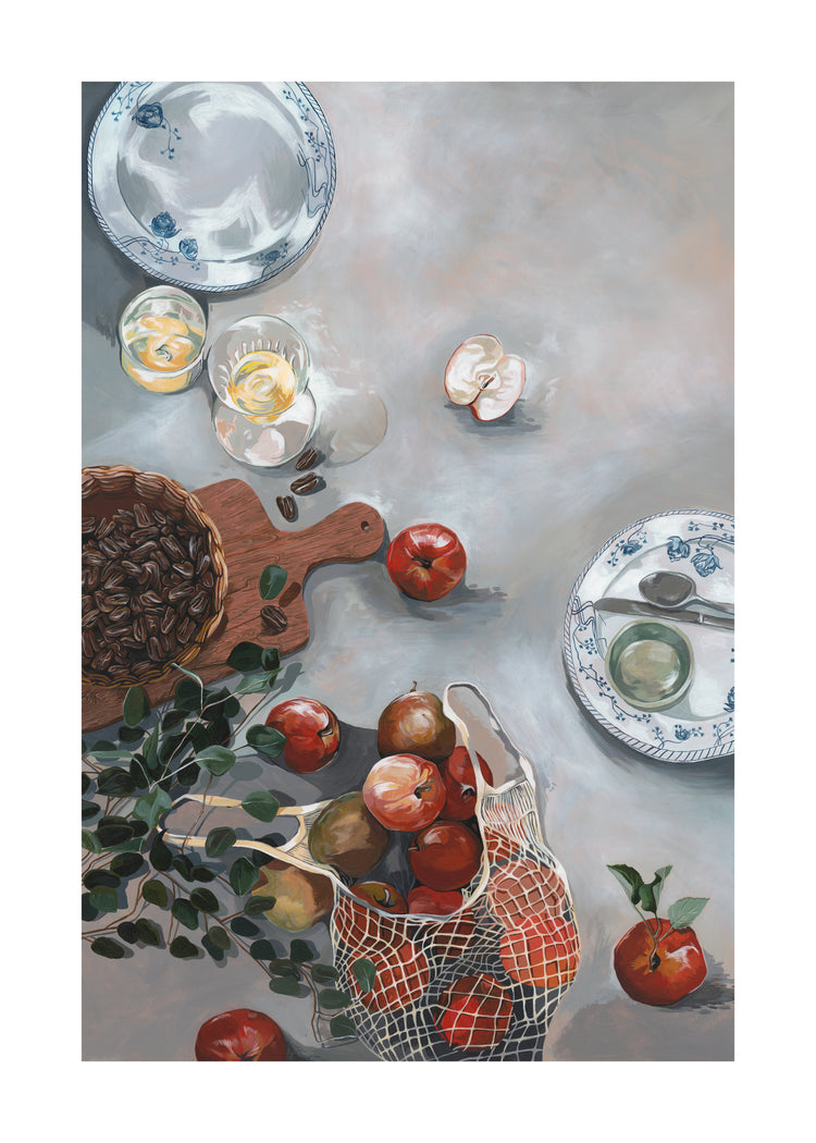 The How Do You Like These Apples poster displays a still life with red apples spilling from a net bag, a cutting board with pecans, two plates featuring a spoon and empty shell, glasses of yellow liquid on the gray surface, and leafy sprigs for warm decor.