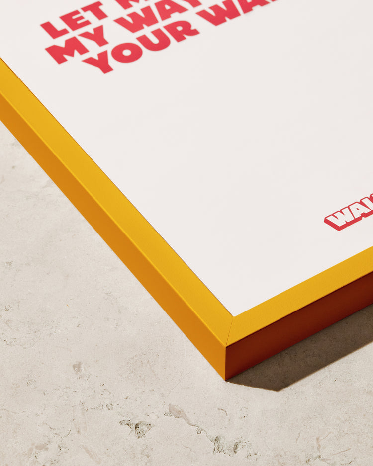 A close-up of the Frame Yellow poster showcases a stylish color pop with an orange frame on a textured light surface. Partial red text reads LET MY WAY BE YOUR WAY, though the rest is cropped out, making it a perfect complement for any space.