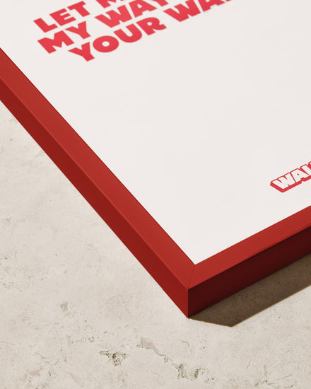 A close-up of the Frame Red poster with bold red text, partially visible and reading Let... My Way... Your Way, adds a stylish pop of color to any space on a textured surface.