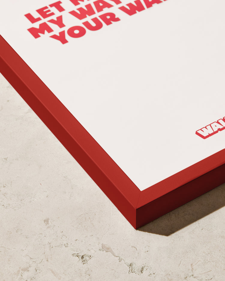 A close-up of the Frame Red poster with bold red text, partially visible and reading Let... My Way... Your Way, adds a stylish pop of color to any space on a textured surface.