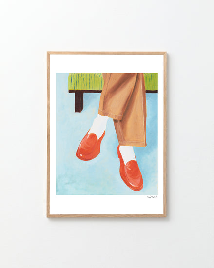 Framed artwork of red shoes, beige pants, and white socks against a blue background.