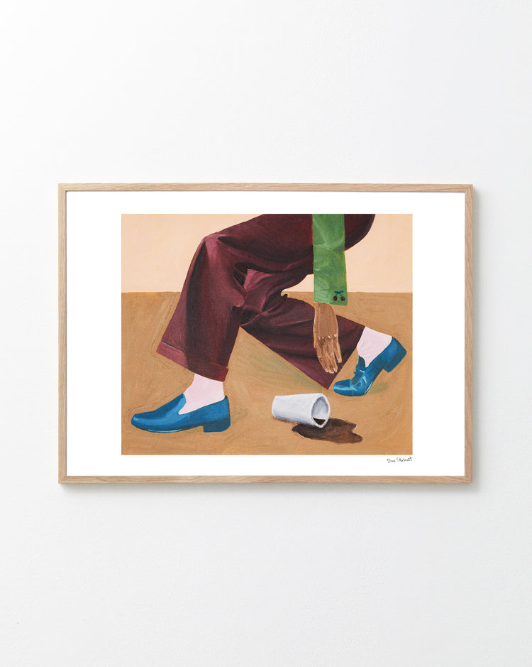 Framed artwork of legs in blue shoes and brown pants on a wooden floor.