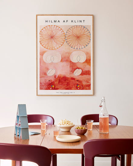Dining room with a Hilma af Klint artwork on the wall above a table with chairs.