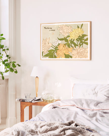 Floral artwork on a wall above a bed in a bedroom