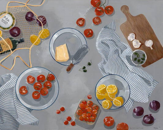 The Like Nonna Used to Make Poster depicts a cozy kitchen scene with fresh tomatoes, lemons, garlic, and onions on a gray surface. A wooden board and cheese grater enhance the charm, while striped cloths and a wine and cheese basket add vibrancy.