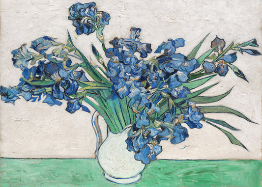 Painting of blue irises in a white pitcher on a table.
