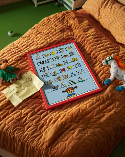 Pippi Longstocking Swedish alphabet poster A–Ö on a child’s bed in a kids’ room.