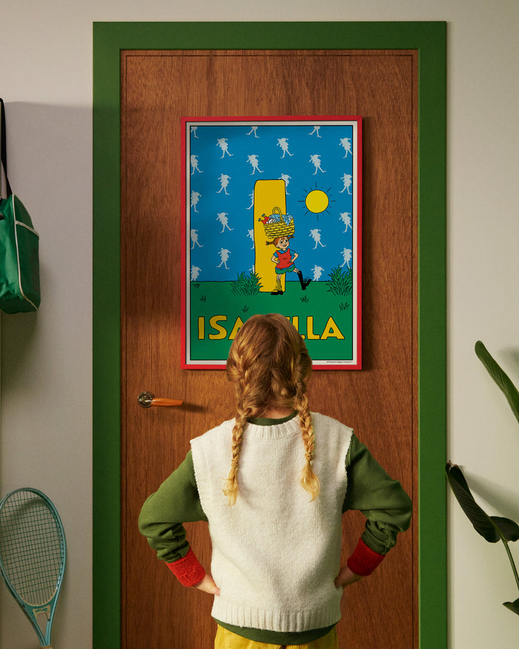 Pippi Longstocking personalised poster featuring the letter I hanging on a door, with a child curiously looking at the artwork.