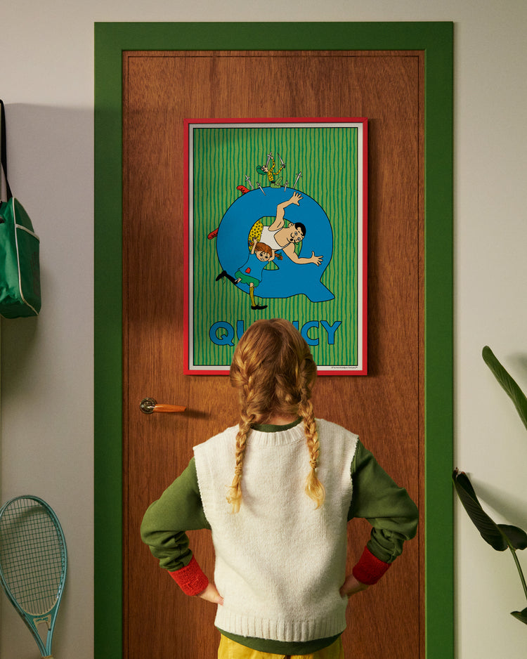Pippi Longstocking personalised poster featuring the letter Q hanging on a door, with a child curiously looking at the artwork.