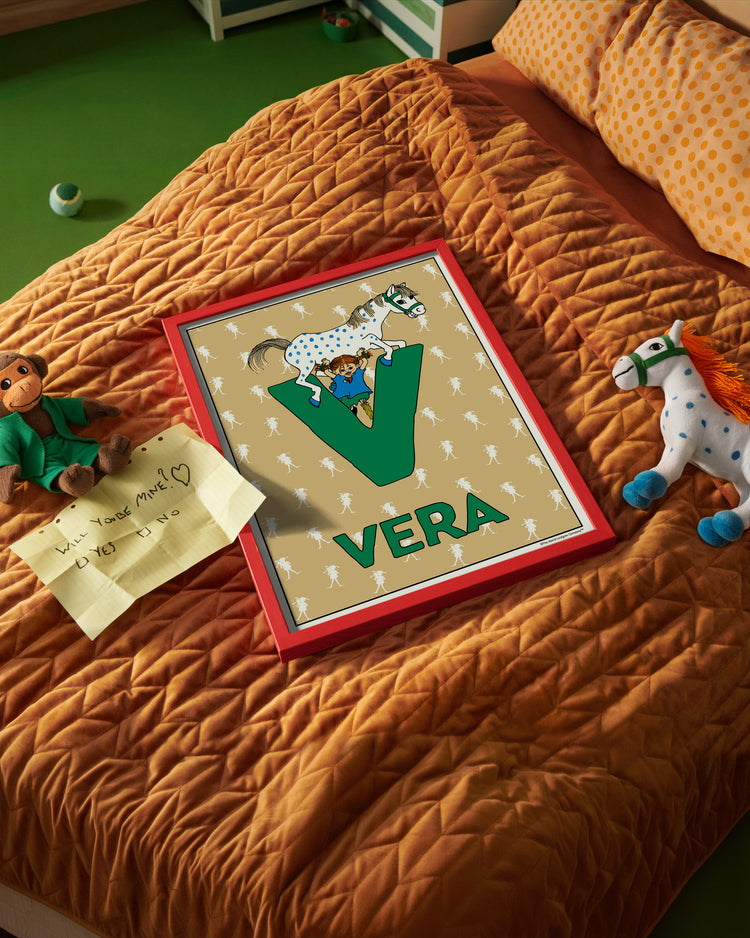 Pippi Longstocking name poster with the letter V and the name Vera, placed on a neatly made bed in a bright kids’ room.