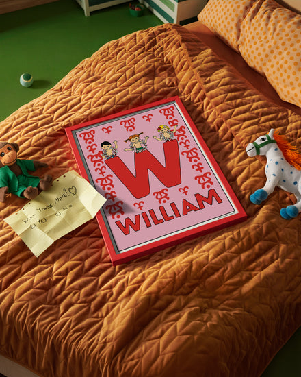 Pippi Longstocking name poster with the letter W and the name William, placed on a neatly made bed in a bright kids’ room.