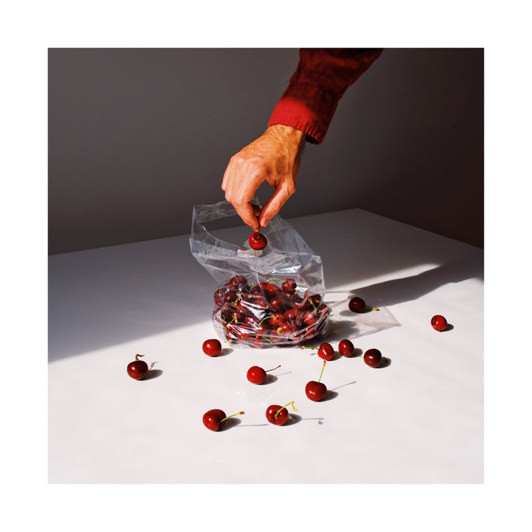 The Summer Treats Poster depicts a hand in a red sleeve picking a cherry from a clear plastic bag filled with cherries on a white surface, with several cherries scattered around.
