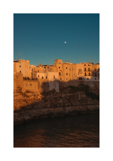 Italian town with old houses illuminated by the rays of sunshine during sunset.
