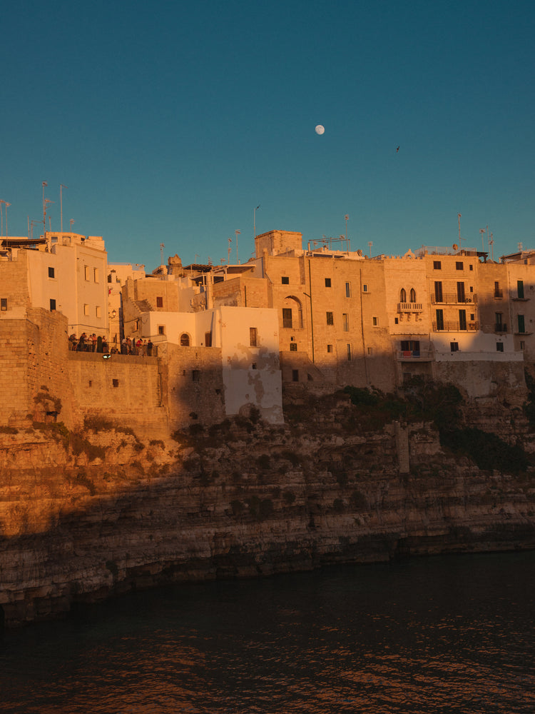 Italian town with old houses illuminated by the rays of sunshine during sunset.